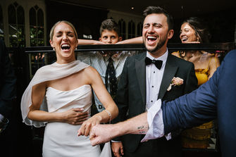 Bride and groom laughing during magic show