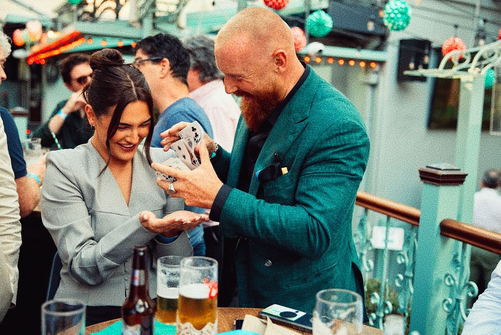 Rua Gleeson performing close-up card magic for guests at a live event