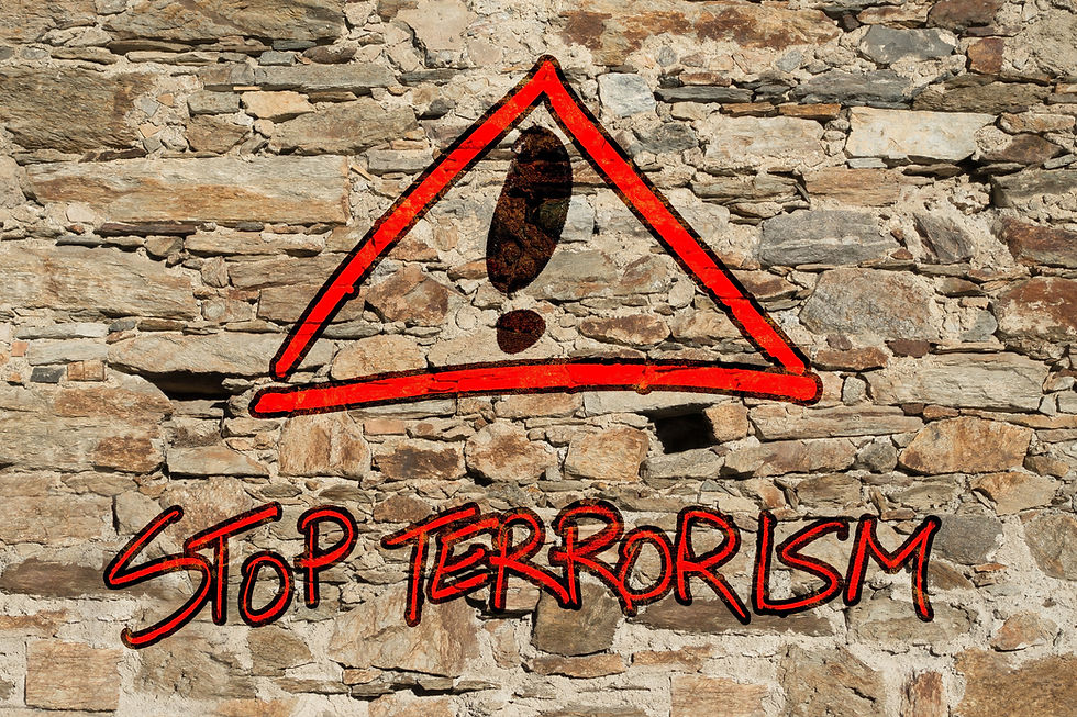 stop terrorism written on a stone wall with an exclamation point in a triangle