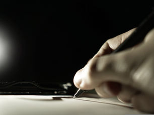 hand writing a signatures on a piece of paper