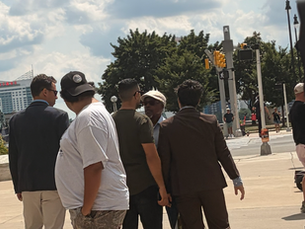 Campaign personnel block heckler (in the cream-colored hat) from the podium. Photo by MIRS.