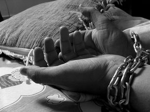 hands bound by a chain