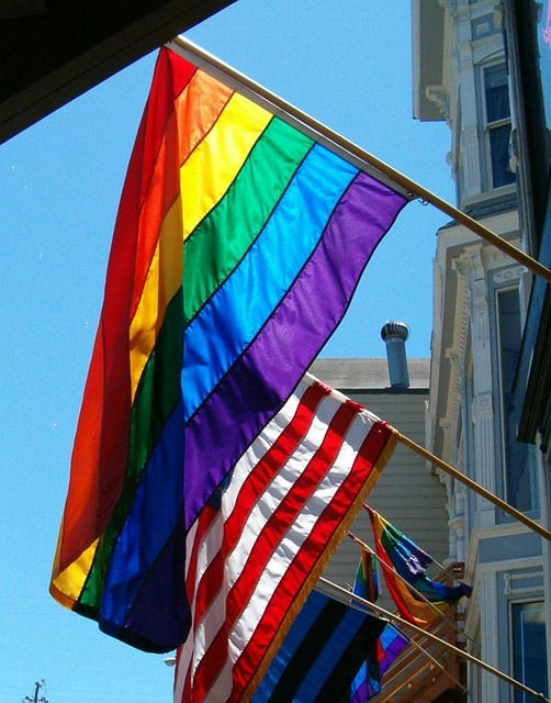 Rainbow flag and american flag hanging from building
