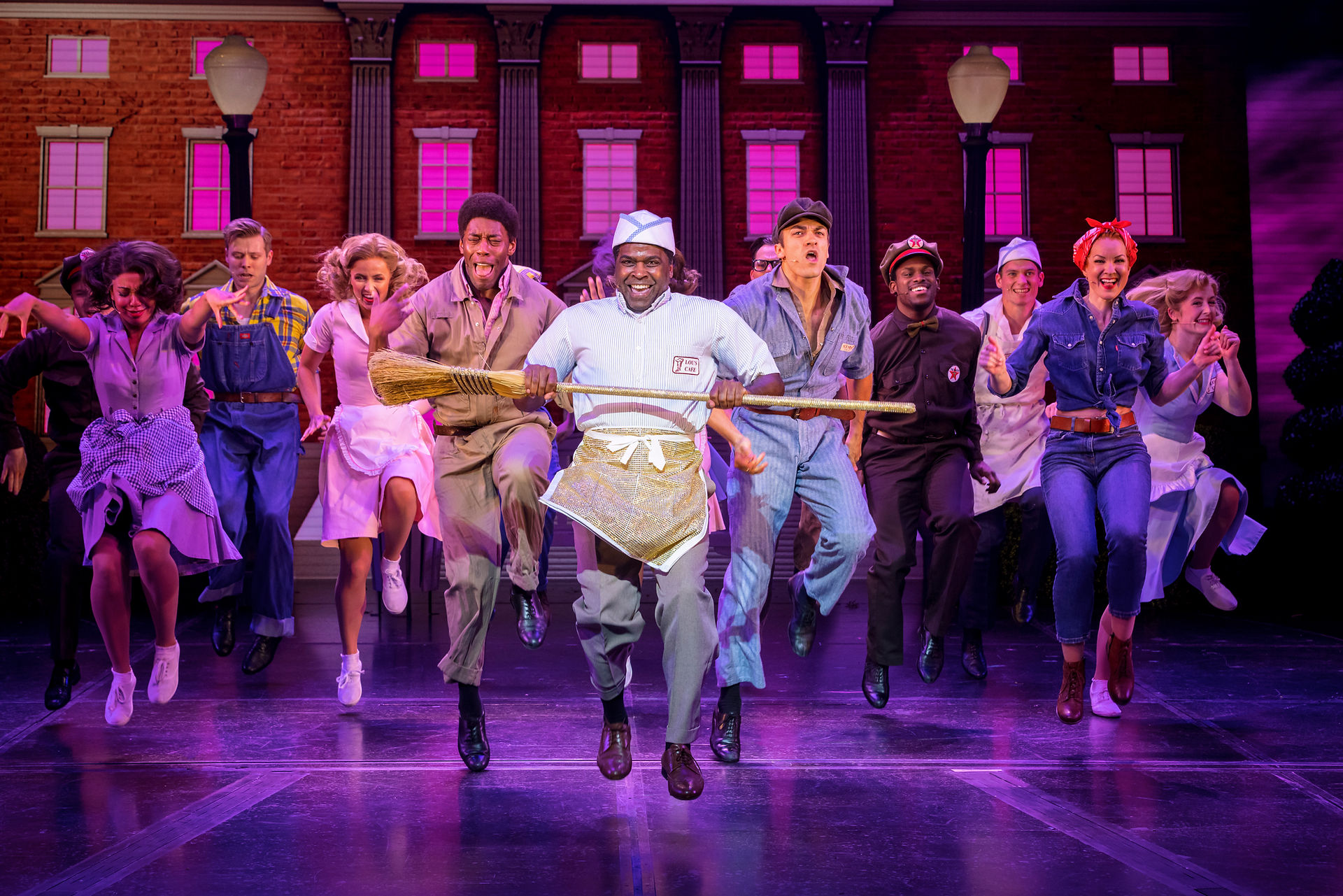 Back Into The Future Musical Adelphi Theatre, performer are dancing in different cloths, purple lighting on stage