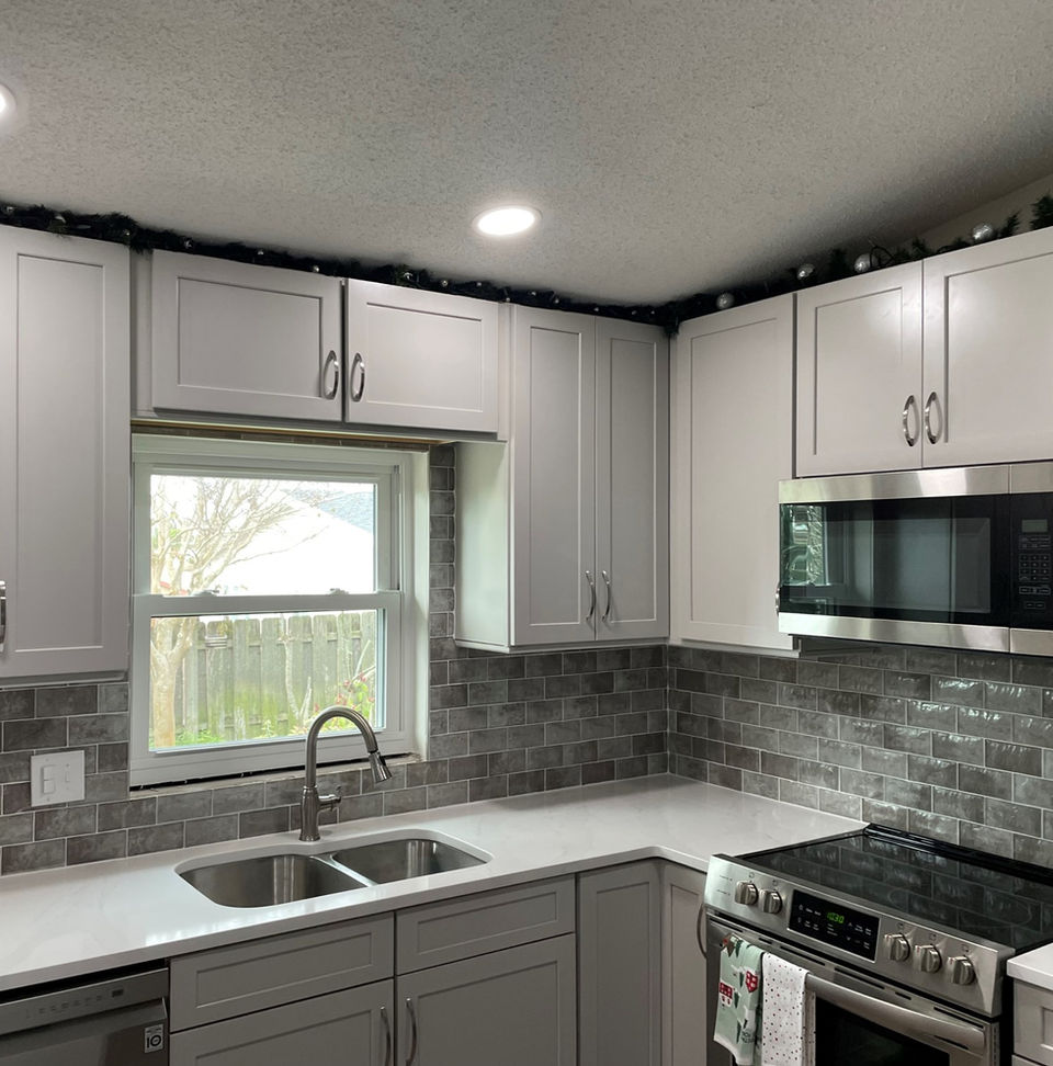 Modern kitchen remodel with gray cabinets and stainless steel appliances, Gjgdinterieur.