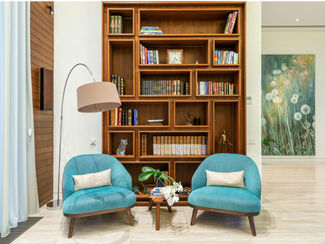 two chairs in a room with a bookcase