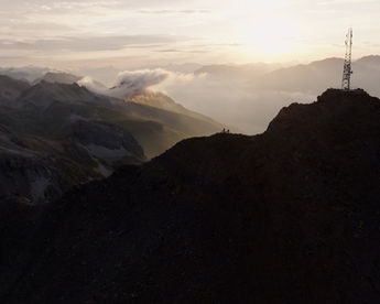 Mountain bikers standing on a cliff on sunrise.