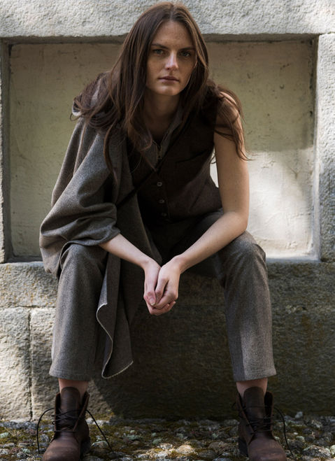 woman sitting on a bench in a gray dress. 