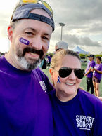 Picture of 2 people wearing purple shirts posing for selfie