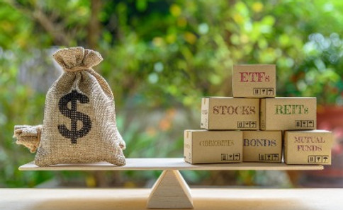 Bag of money and stocks on a seesaw