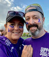 Picture of 2 people wearing purple shirts posing for a selfie