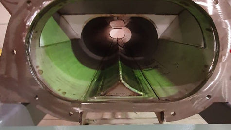 A close-up view of a screw conveyor, an essential mechanical apparatus, designed with a spiral auger inside a metal housing, employed for the efficient movement of bulk materials in manufacturing and processing industries