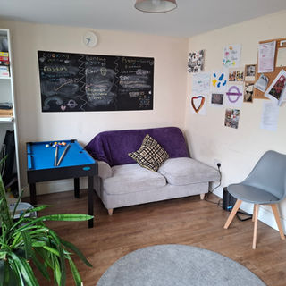 Cozy room with sofa, blackboard, and game table at Onkar House
