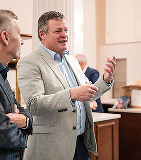 Man speaking and gesturing to two listeners