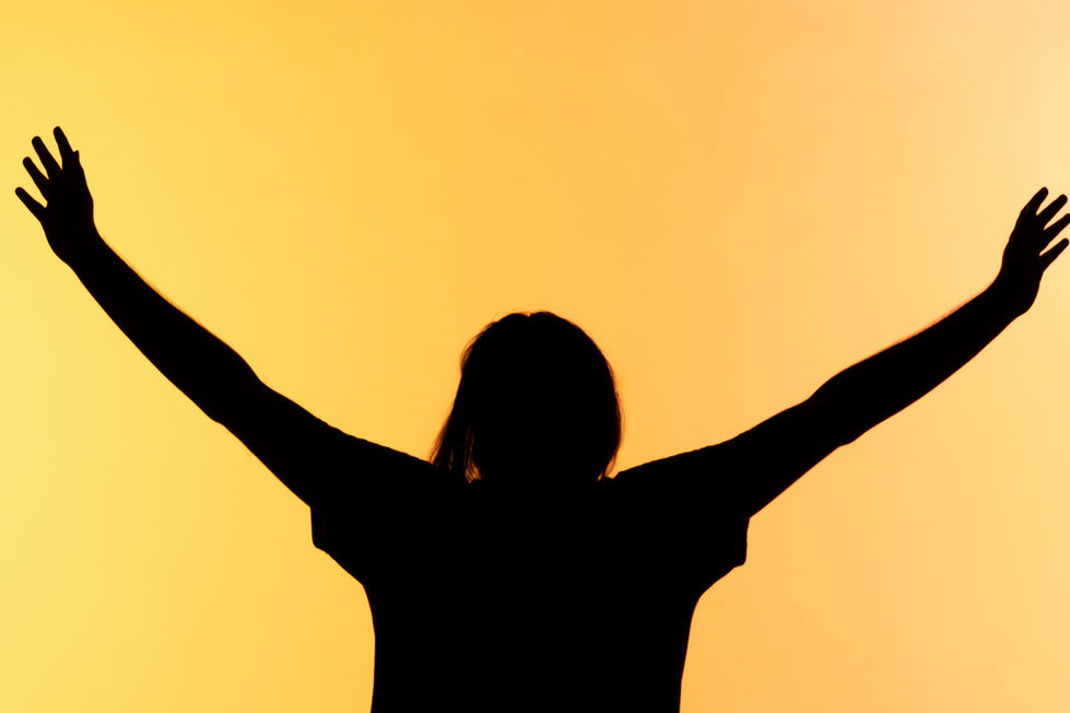 Silhouette of person with arms raised against an orange and yellow background.