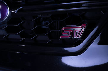 Close up of Subaru STI logo on vehicle's black front grill.