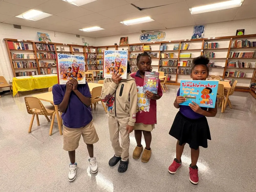 Students holding new books in a school library