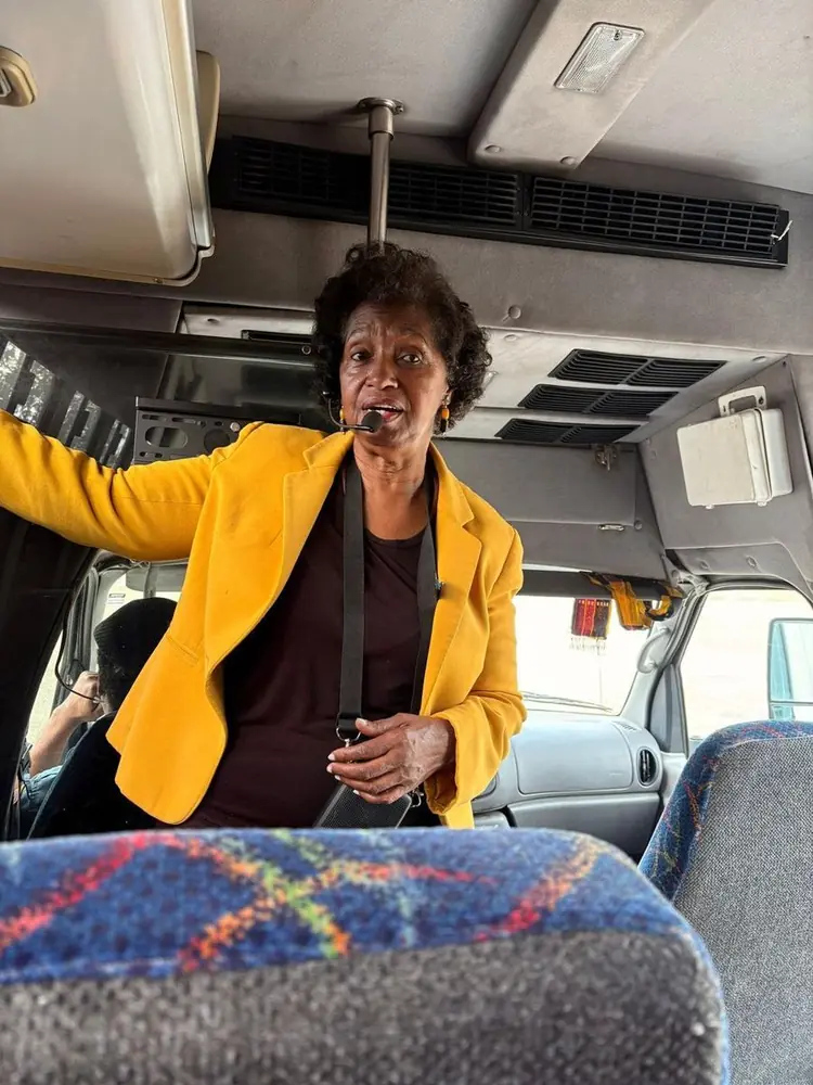 Carla leading students on a field trip bus