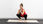 A pregnant woman squatting with a dumbbell