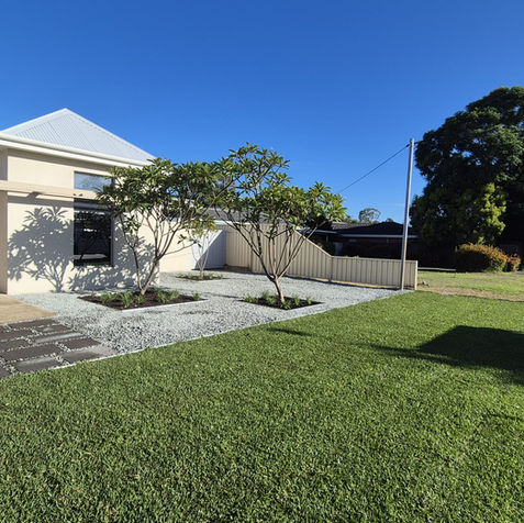 Modern house with landscaped gravel yard and green lawn