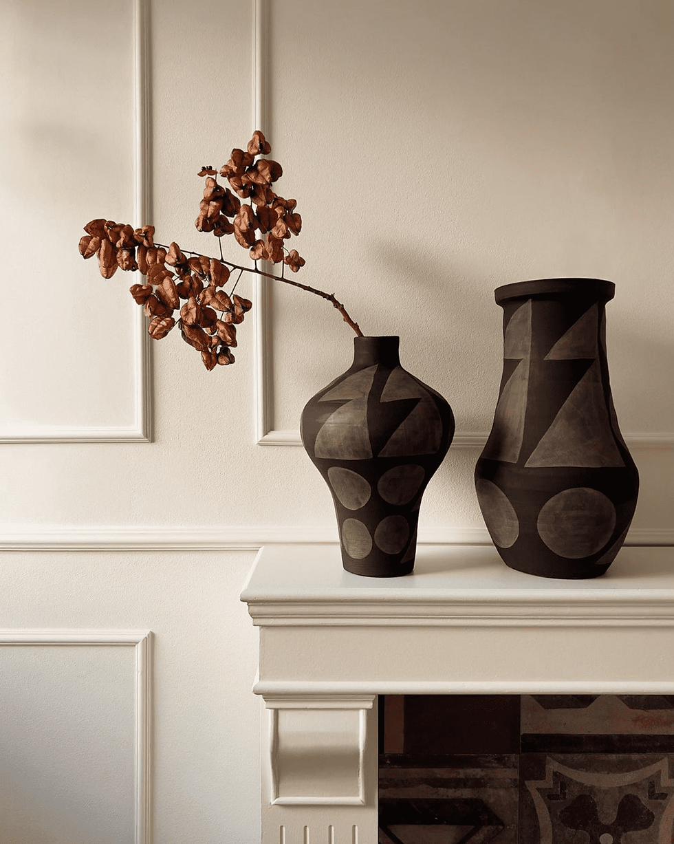 braune Vase mit getrocknetem Zweig,