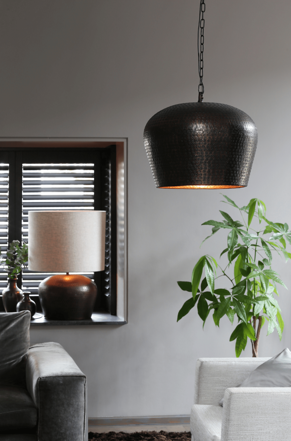 Miniaturbild: Tischlampe mit beigem Lampenschirm vor einer grauen Wand in einem Esszimmer, neben einer grünen Pflanze