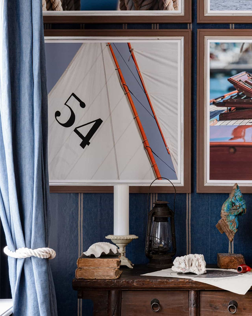 Wandbild mit einem Foto eines Segelbootes auf einer blauen Wandtapete im Maritime-Look