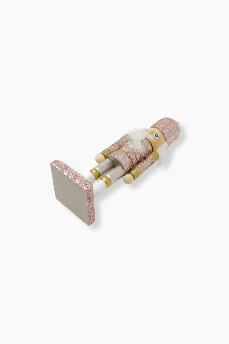 Miniaturbild: Weihnachtsornament in Form eines hölzernen Nussknackers mit einem rosa Anzug und Hug