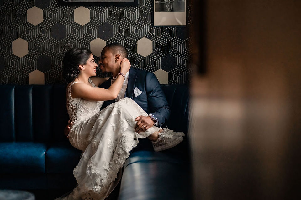 bride and groom posing on a sofa 