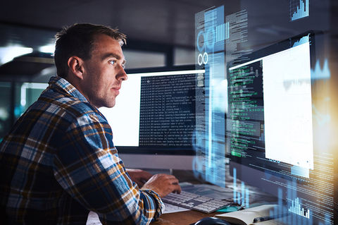 Man looking at screens illustrating process optimization and technology enablement
