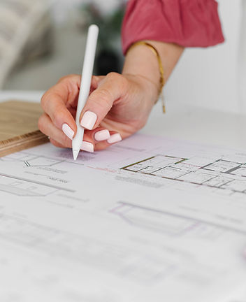 An Irish interior designer analyzing architectural floor plans, reviewing structural layouts and spatial design strategies fo