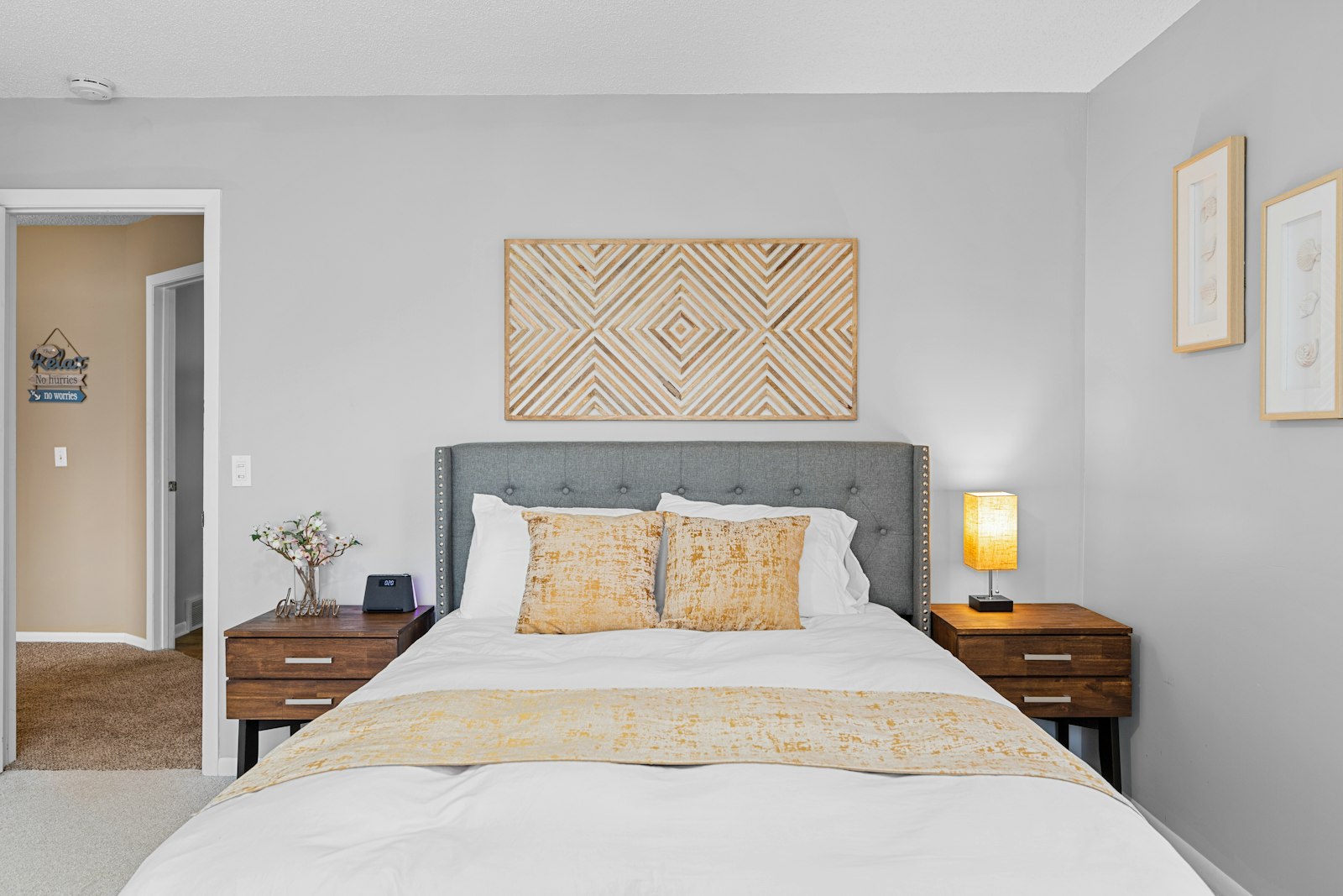 Vacation-rental bedroom with a gray headboard and made bed