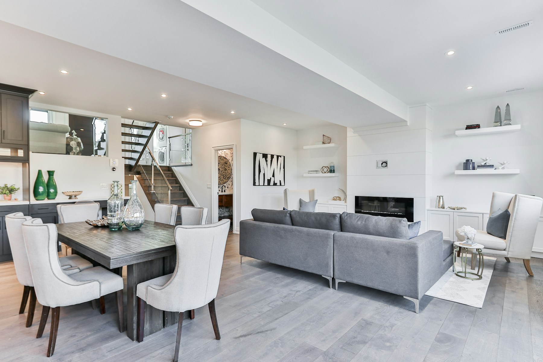 Open rental living and dining room with a gray sofa and fireplace
