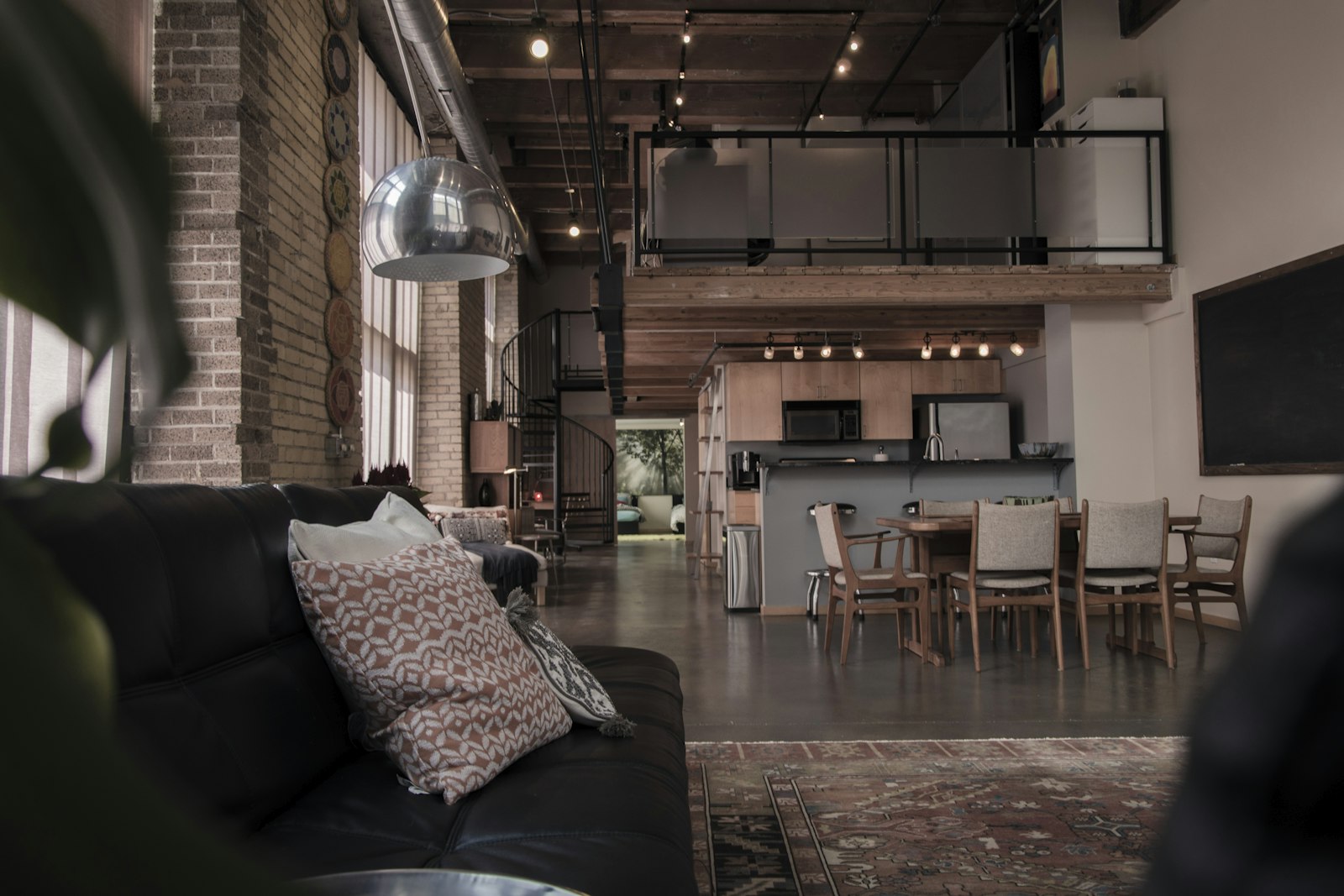 Loft living space with a leather sofa, dining table, and kitchen