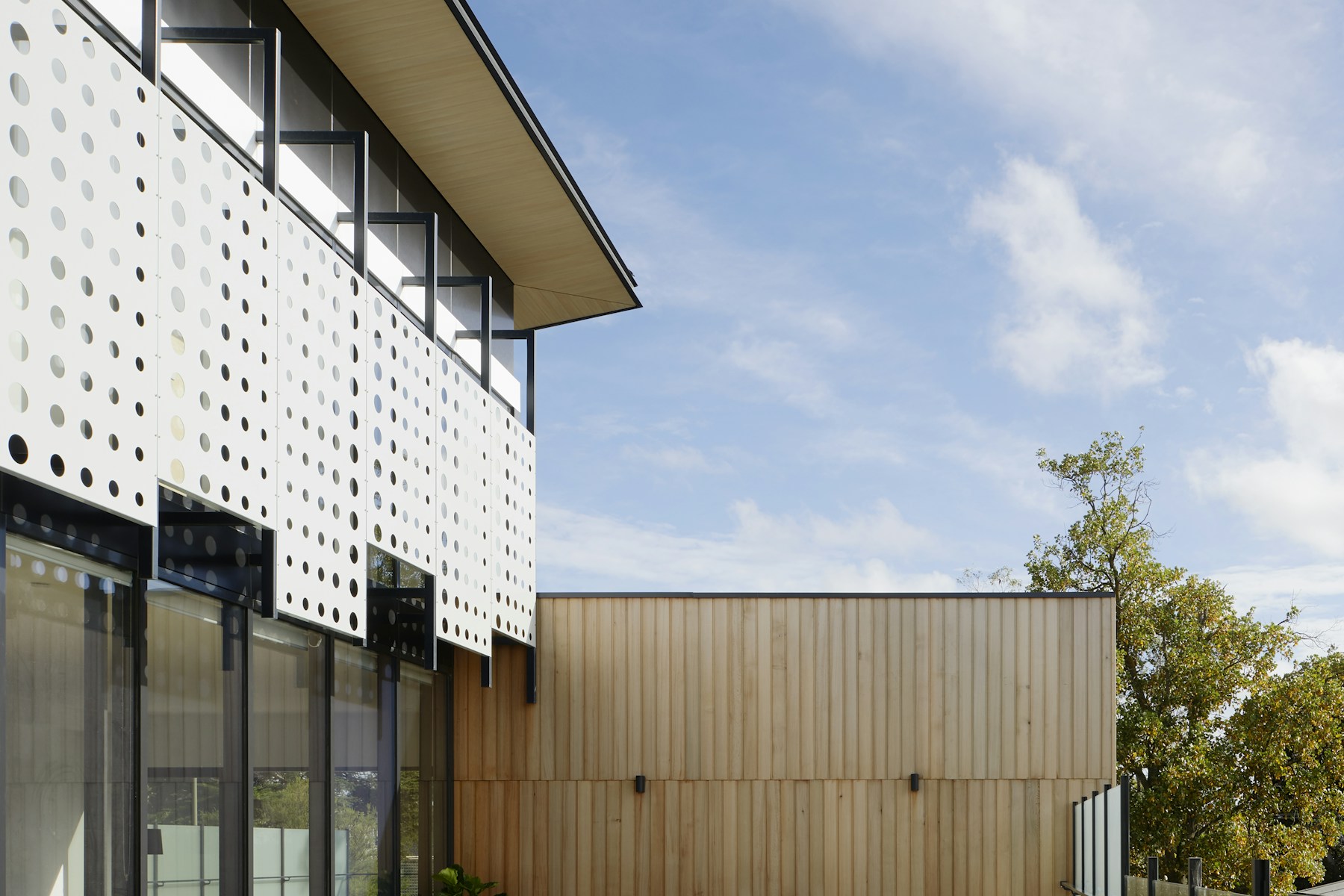 Modern rental exterior with perforated balcony screens and wood siding