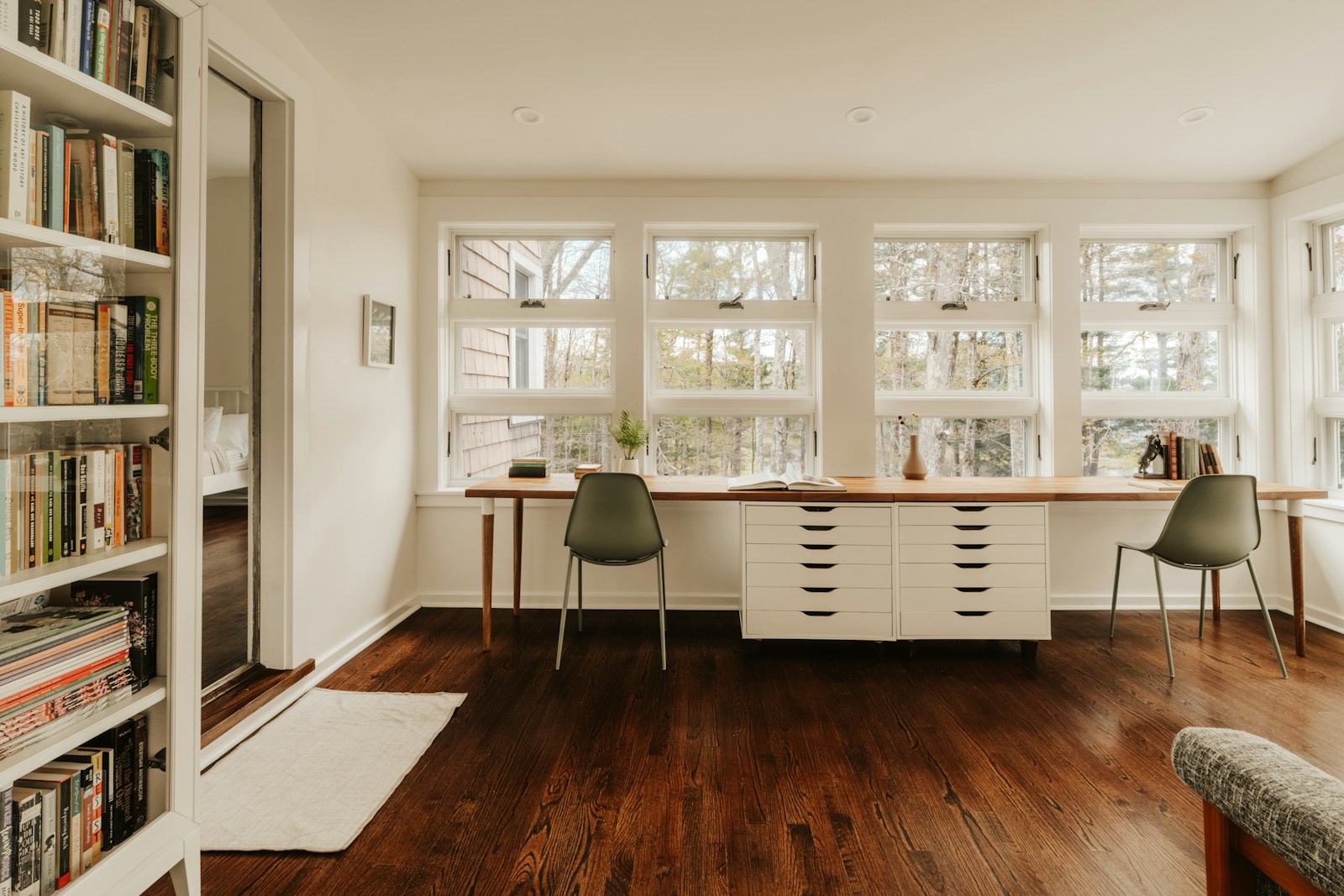 Long wood desk under a wall of windows, no people