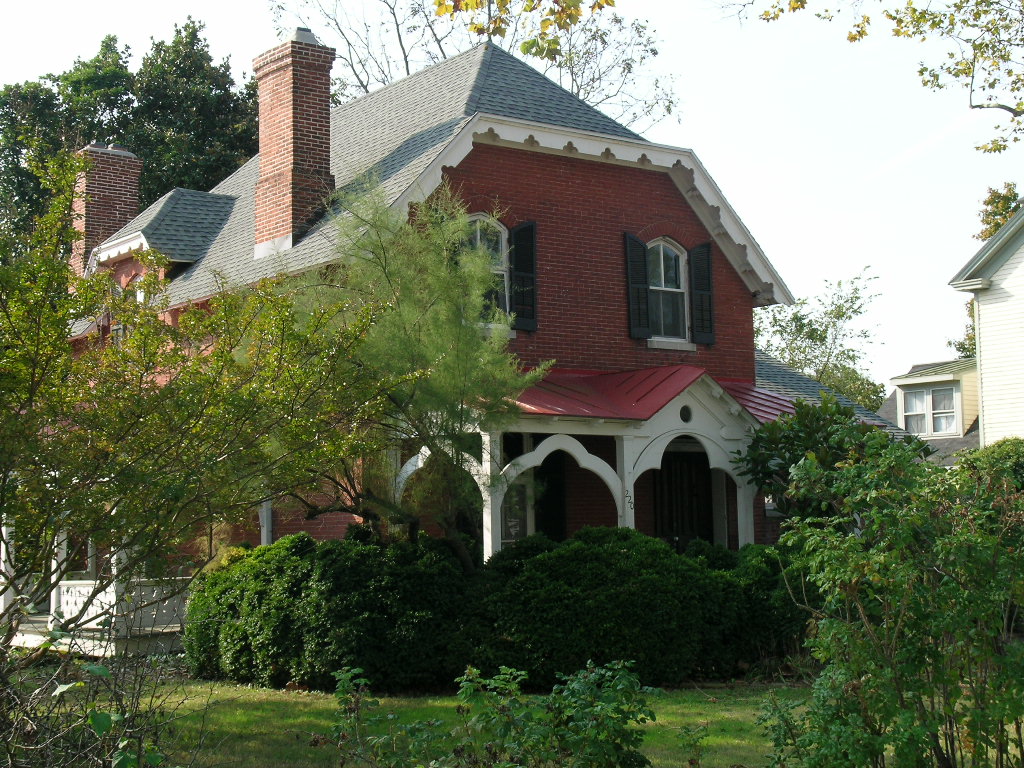 A brick cottage with a red porch roof on South Street in Easton, Maryland.