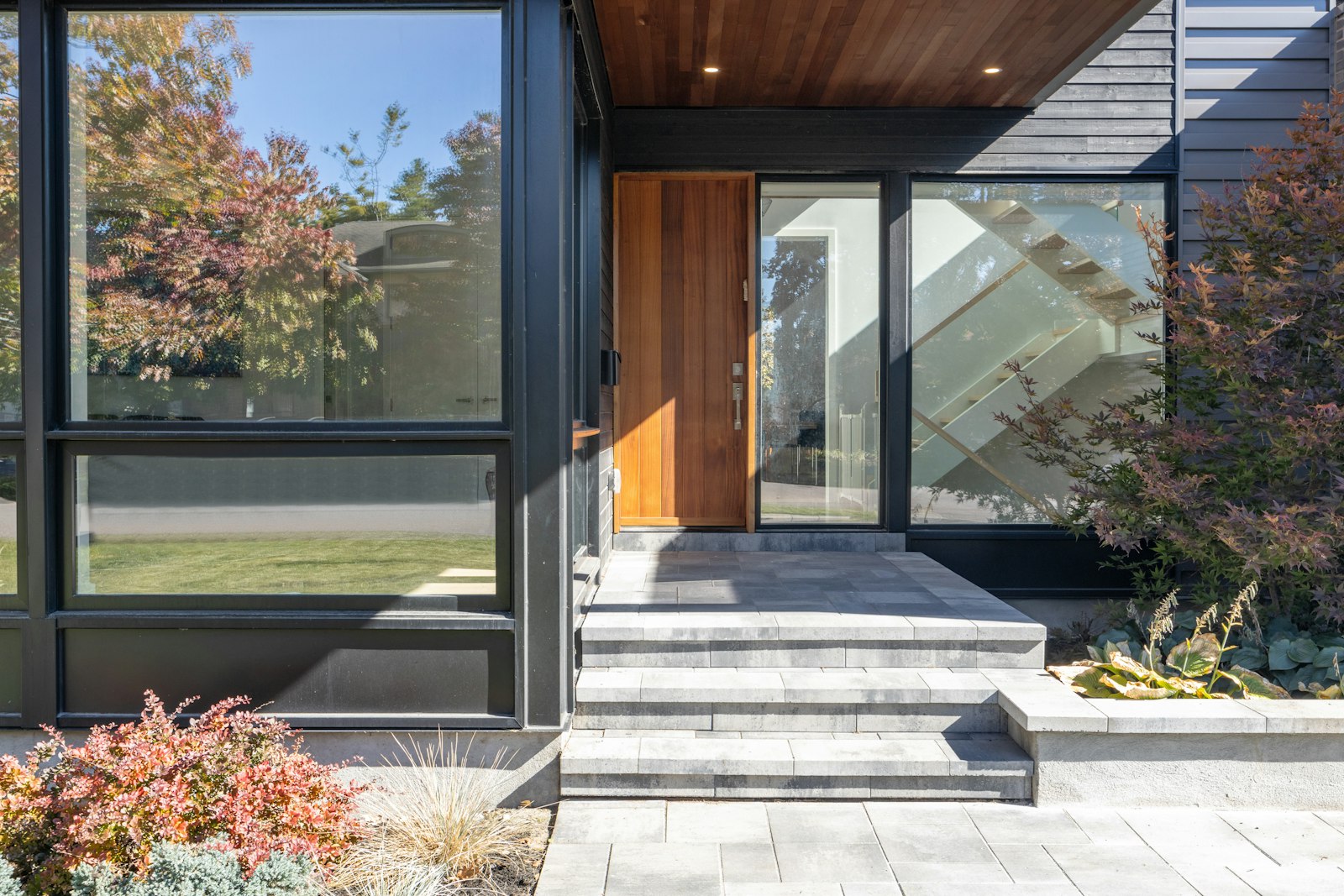 Modern house entry with a wood door and stone steps