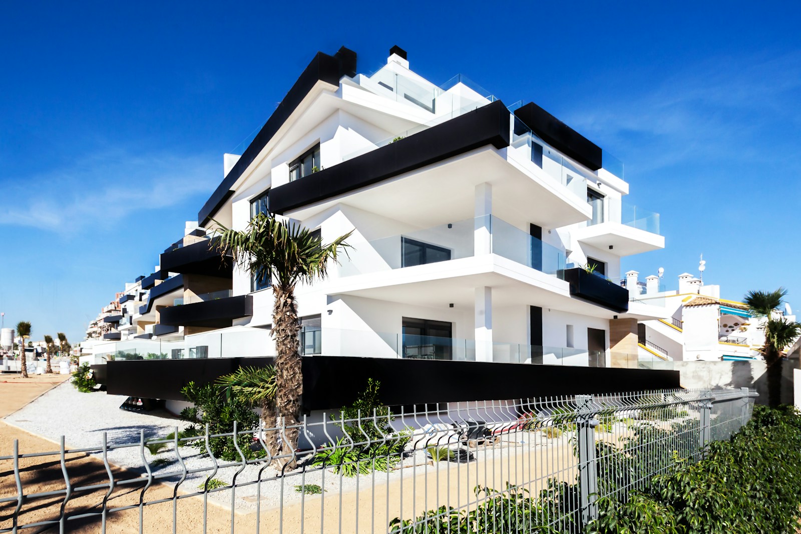 White and black apartment building with empty balconies, no people