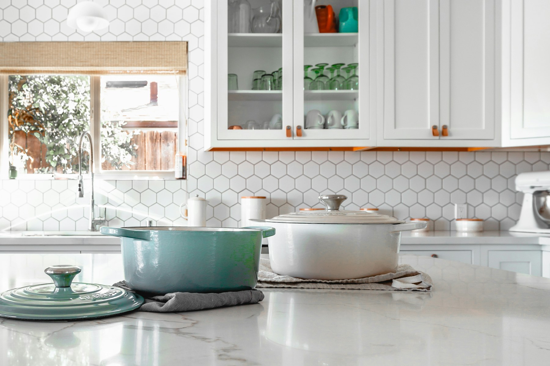 Kitchen island with two Dutch ovens and a white tile backsplash