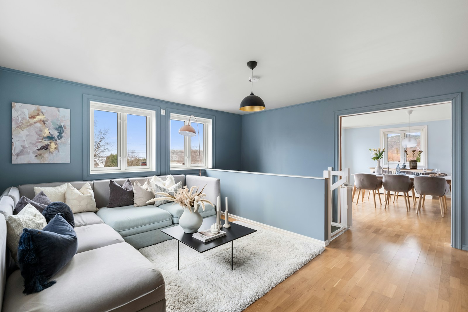 Blue living room with a gray sectional, no people