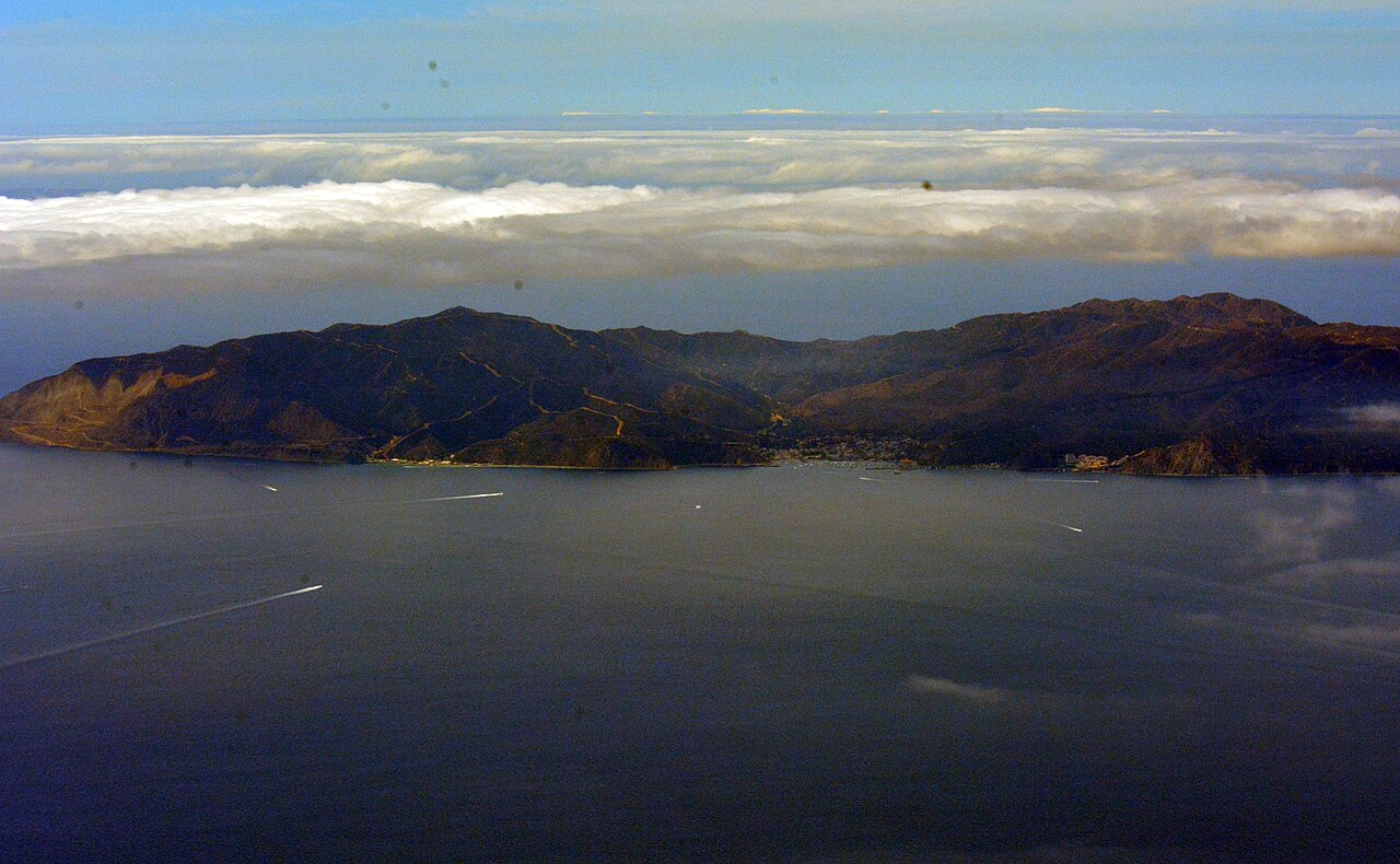 Santa Catalina Island and Avalon Harbor from the air above a marine layer.