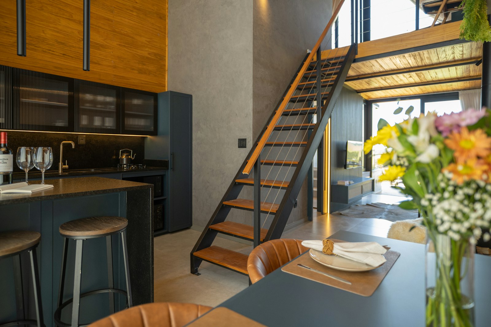 Loft rental kitchen, dining table, and open staircase