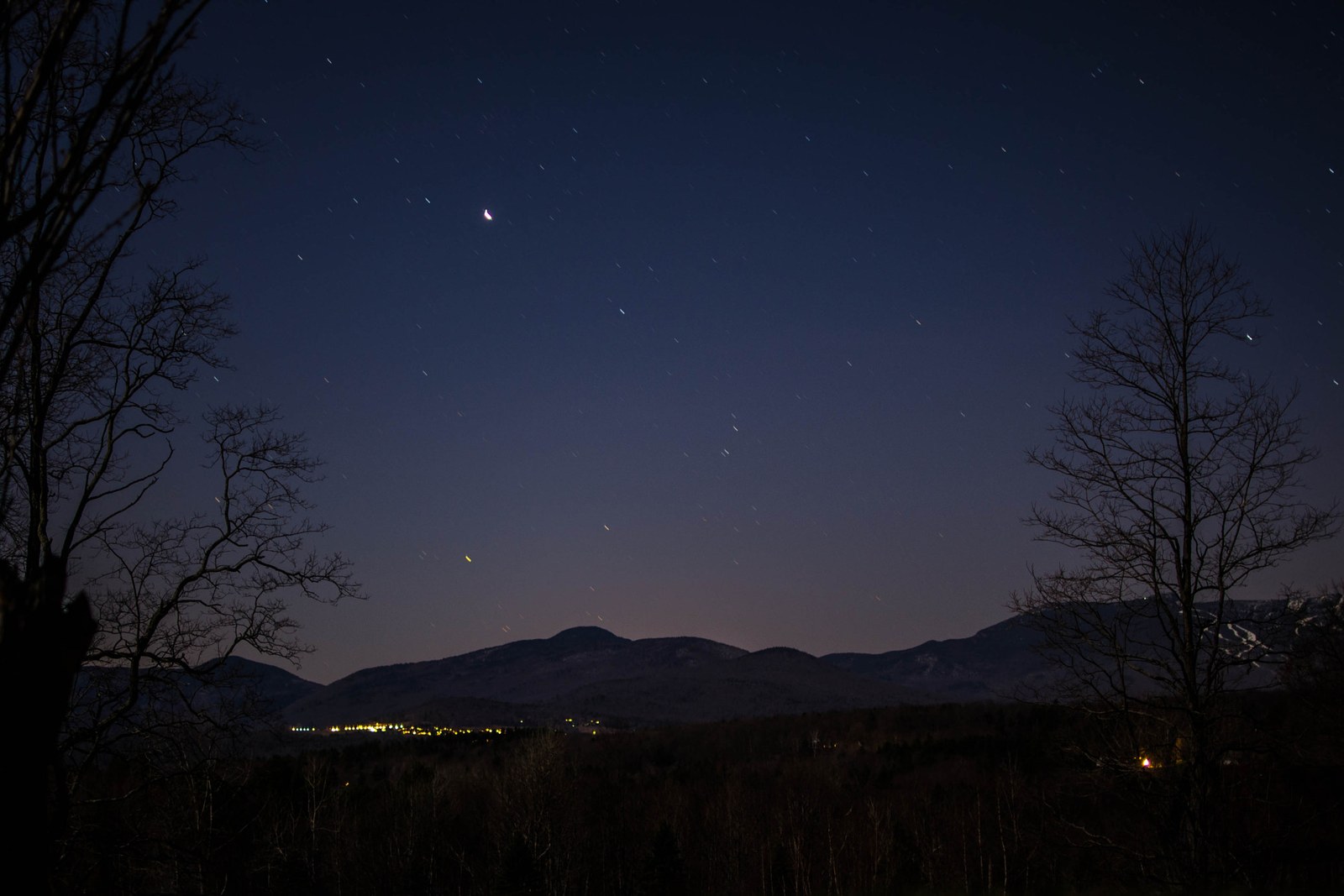 Night sky over Mount Mansfield and the lights of Stowe