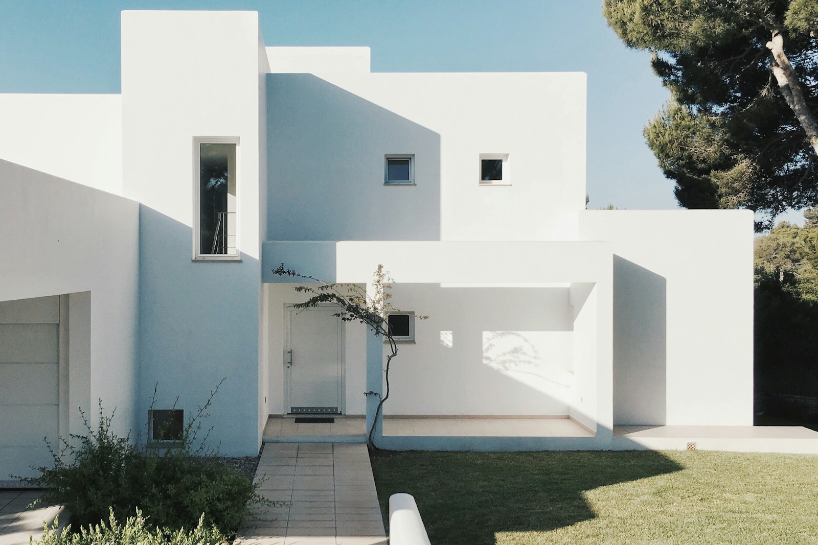 White modern house exterior with lawn, no people