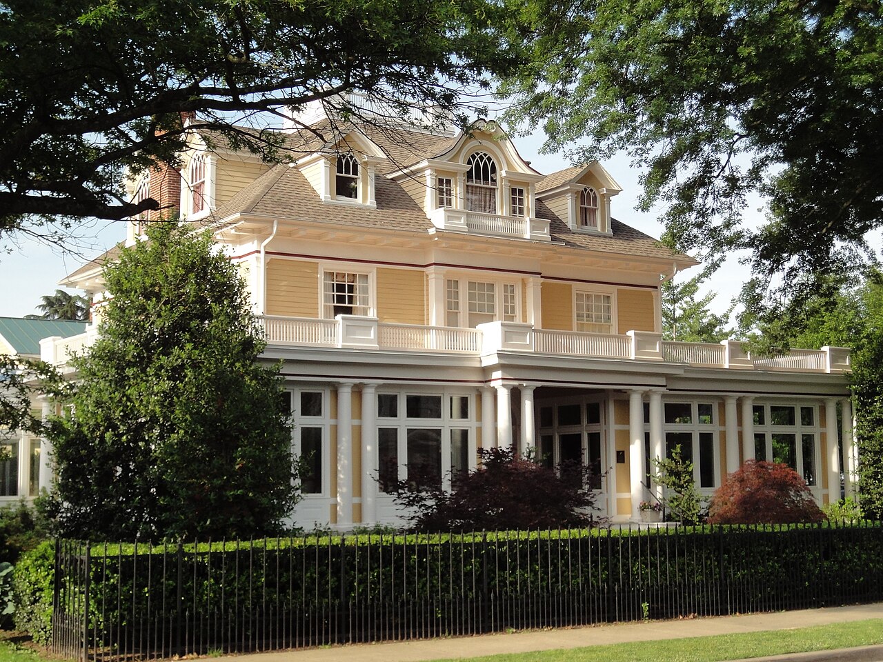 A yellow columned house behind a hedge in Easton, Maryland.