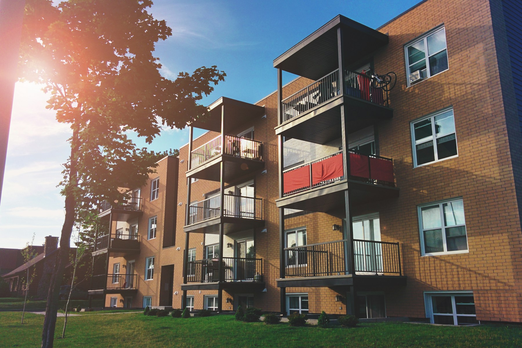 Brick apartment building with balconies and a front lawn