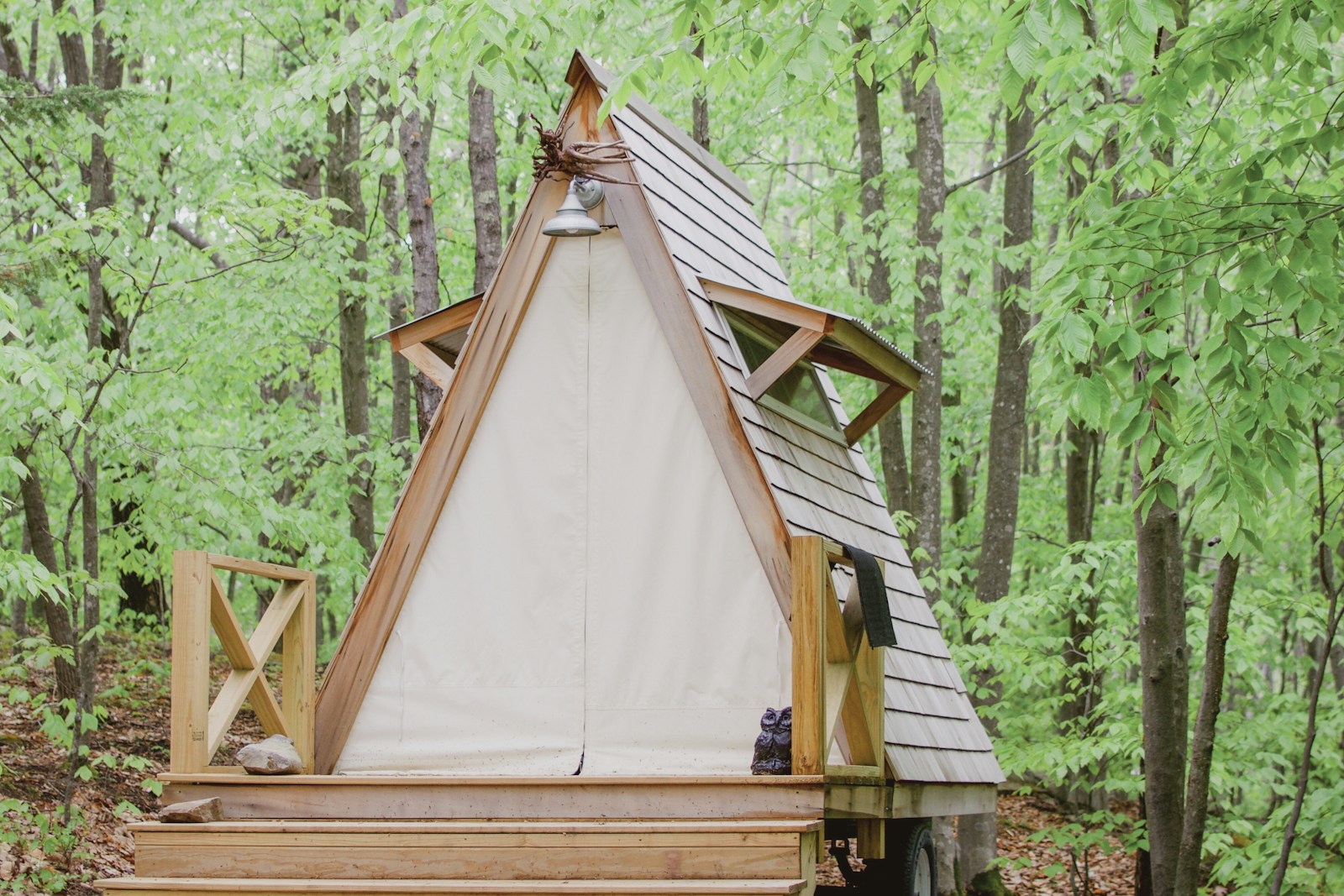 Wood A-frame cabin in green woods, no people