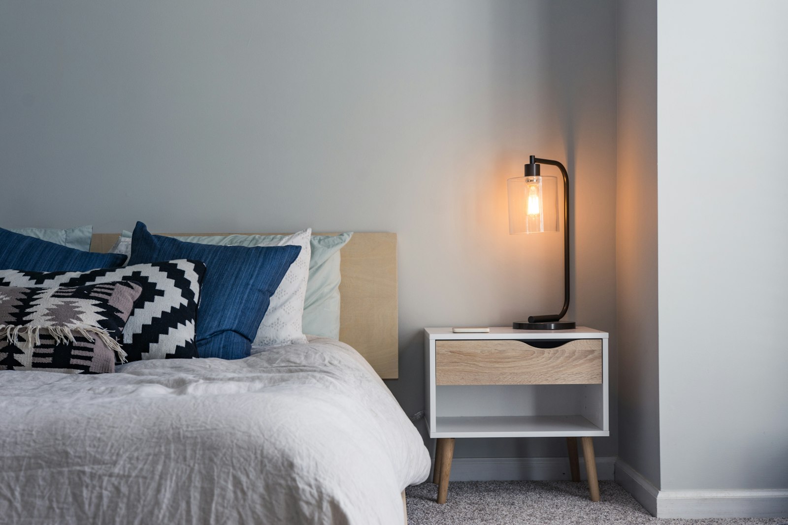 Short-term rental bedroom with lamp and white bedding