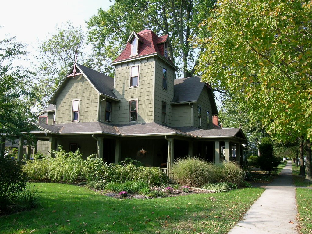 A green shingle house and sidewalk on Aurora Street in Easton, Maryland.